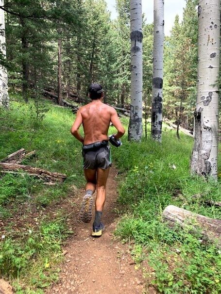 Runner jogging along a forest trail at an easy training pace